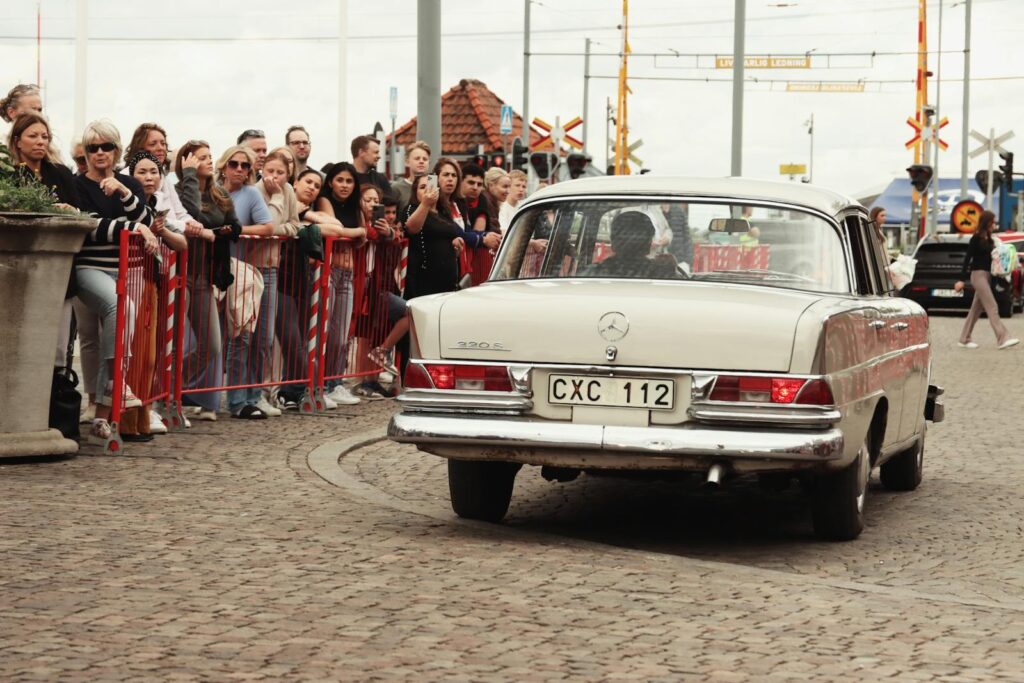 Classic Mercedes-Benz car driving by crowd during Jönköping exhibition.