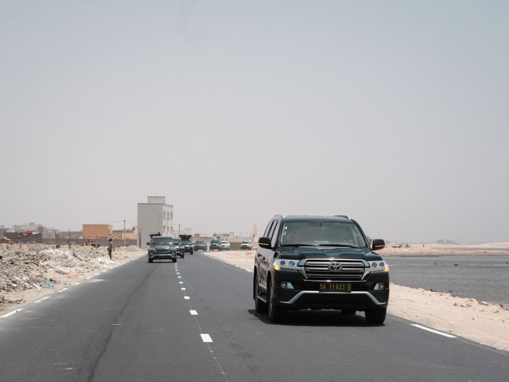 SUV cruising on a deserted highway by the coast, showcasing adventure and travel.