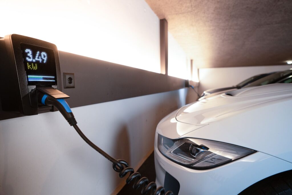 White electric car charging at indoor station, emphasizing sustainability and efficiency.