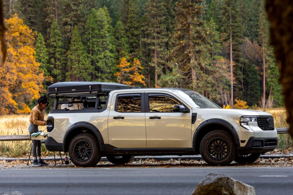 Camping adventure with a pickup truck in a scenic autumn forest setting.