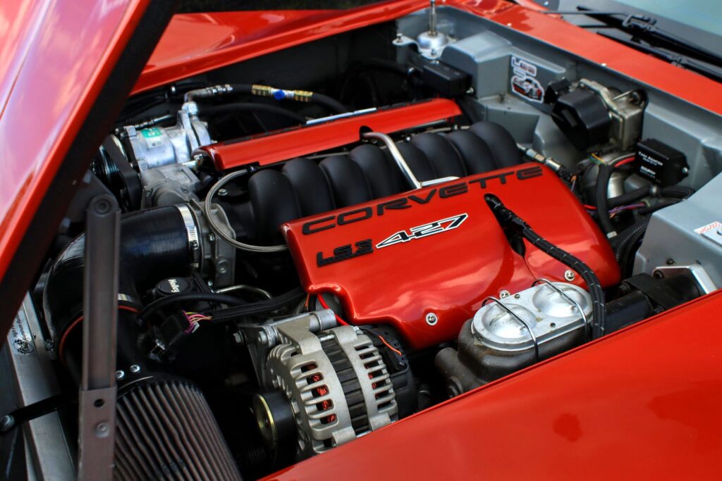 Close-up of a Corvette LS7 427 engine in a sleek red sports car.