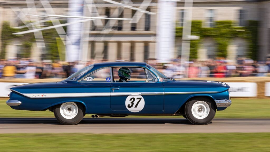 A vintage blue race car speeding at the Goodwood Festival of Speed in England.