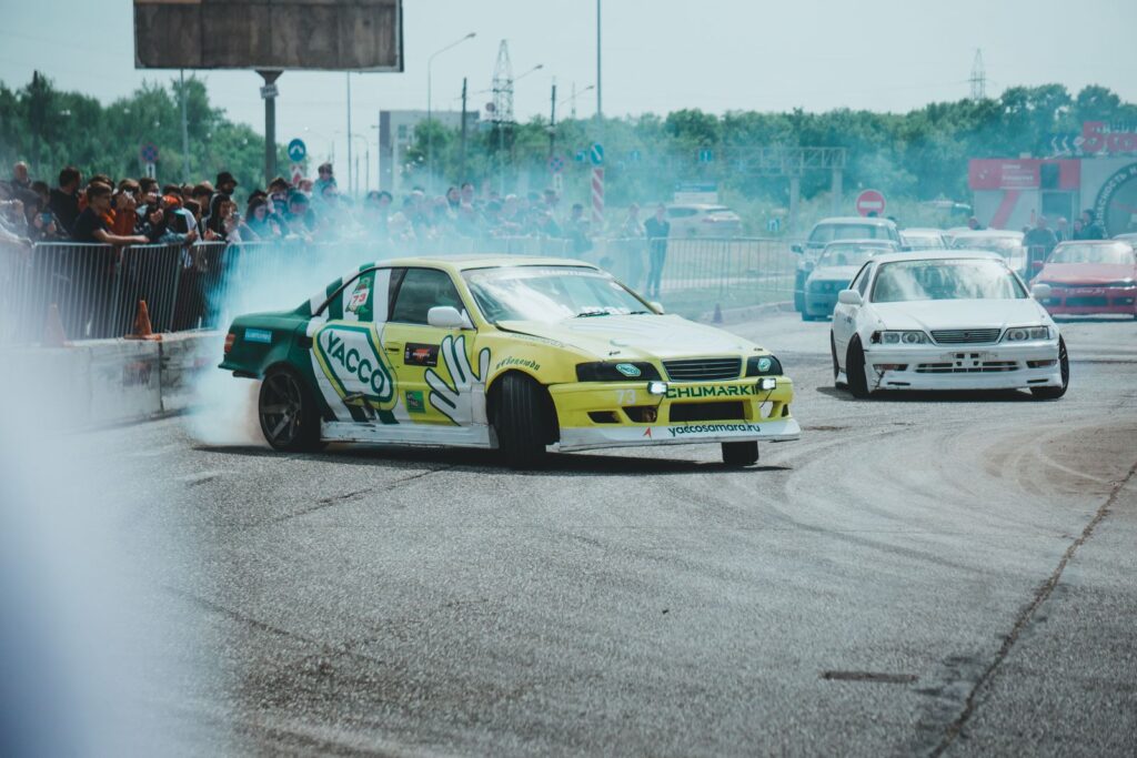 Spectacular car drifting event in an urban setting with skilled drivers and enthusiastic spectators.