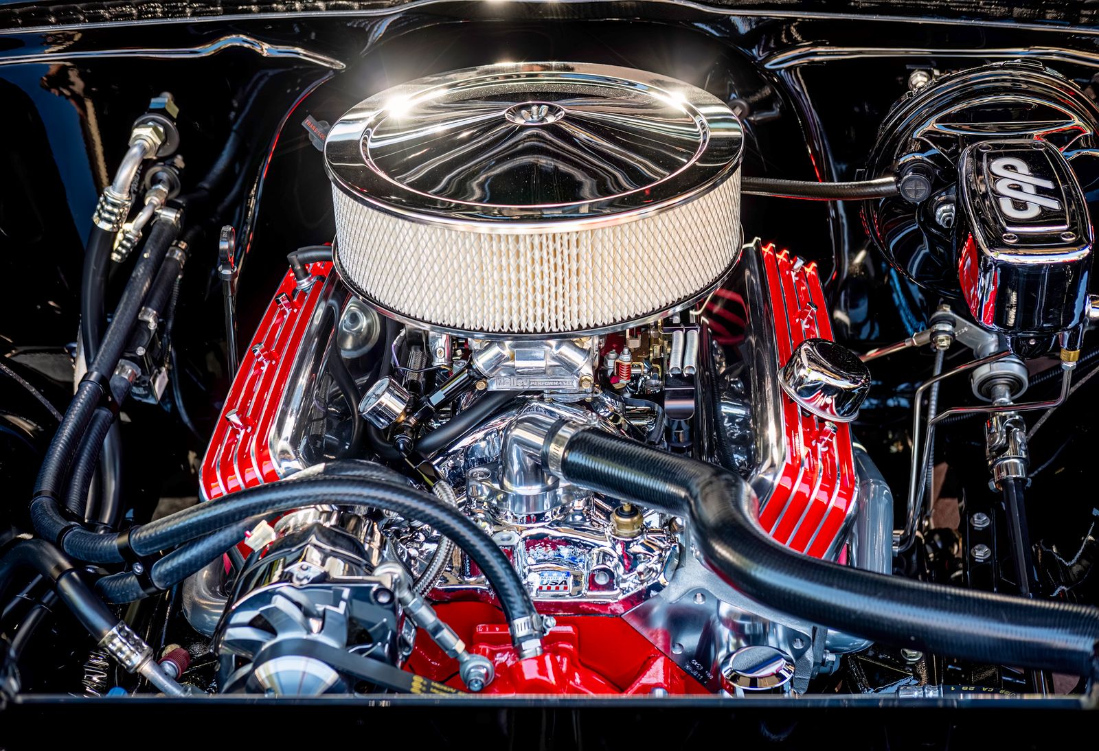 Close-up of a polished and high-performance car engine with visible components and pipes.