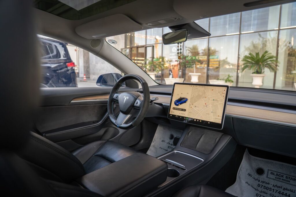 Tesla Model 3 interior showcasing navigation screen and sleek design, ideal for modern automotive themes.