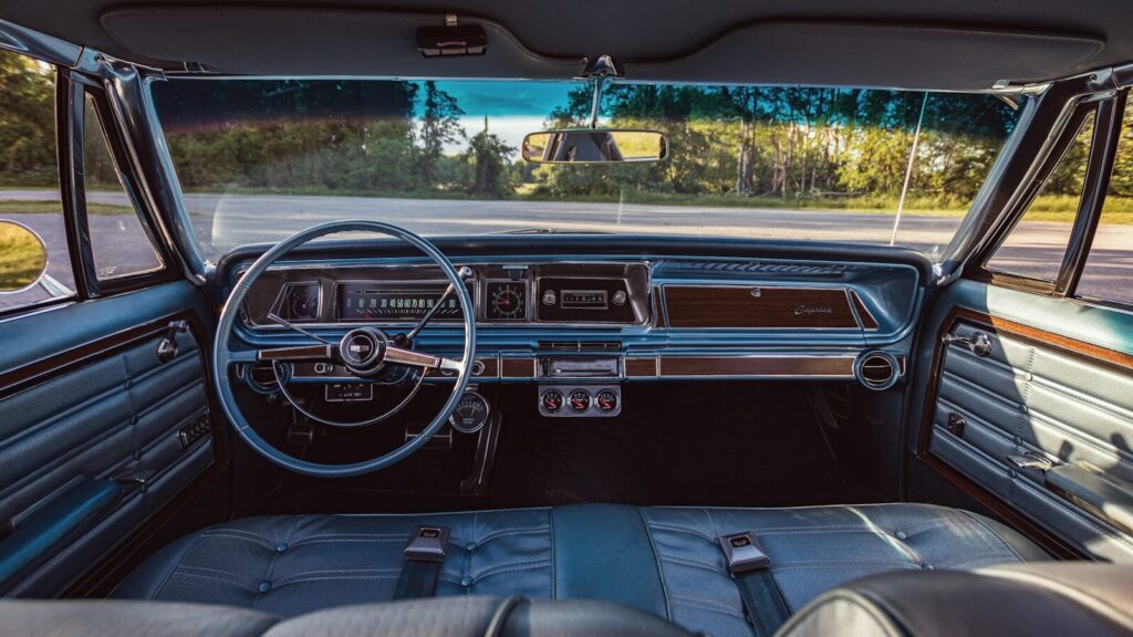 The interior of a car with a steering wheel and dashboard