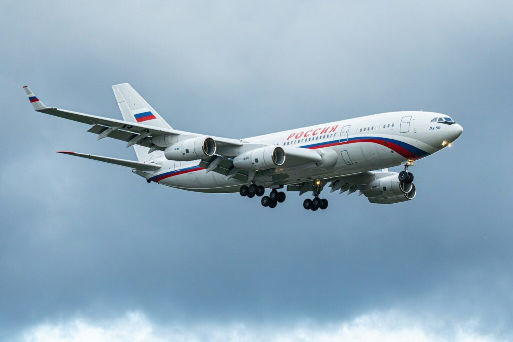 A white airplane with russian flag and text flying