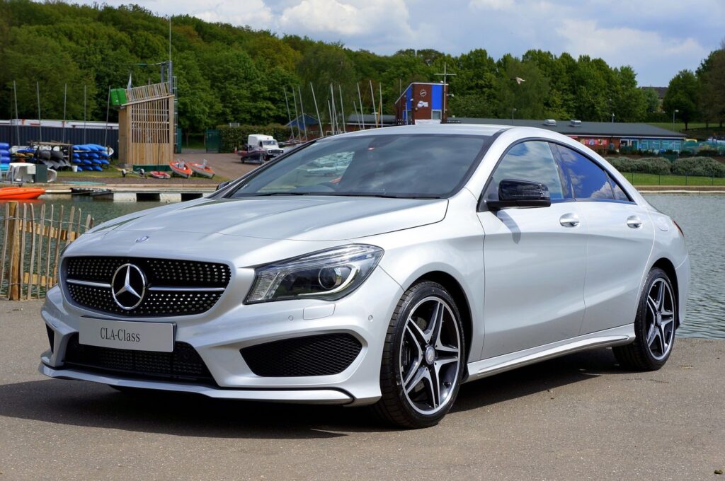A sleek Mercedes-Benz CLA-Class car parked by a river, showcasing its luxury design.