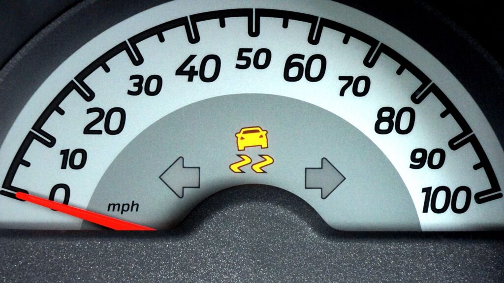 Close-up of a car speedometer displaying a warning indicator. Ideal for automotive themes.