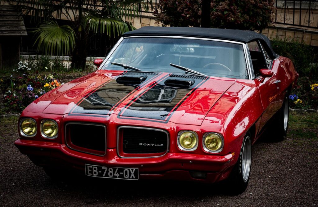 A beautifully preserved vintage red convertible with chrome detailing, exuding classic retro charm.