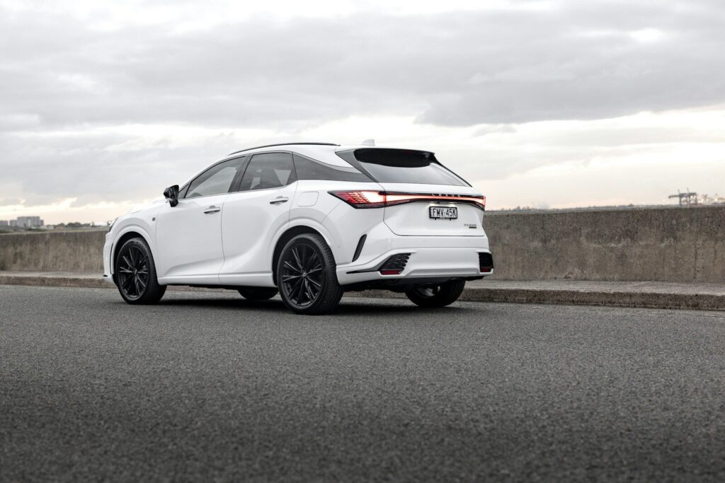 A white lexus suv is parked on the side of the road