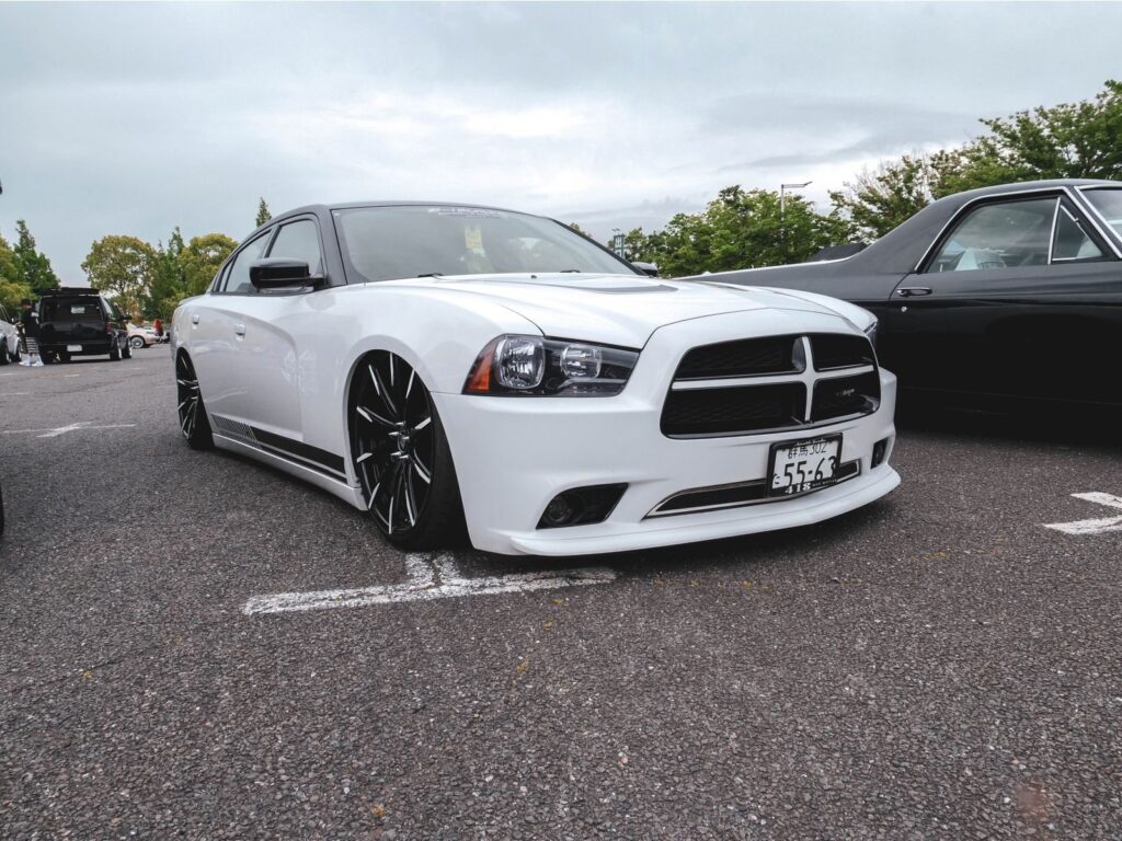 A modified white Dodge Charger parked on asphalt, perfect for automotive enthusiasts and car wallpapers.