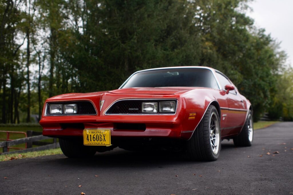 A vintage red Pontiac Firebird parked outdoors in Virginia, capturing classic American muscle car design.