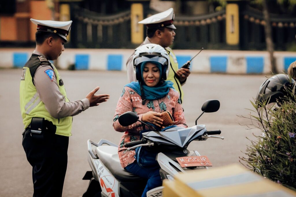 A motorcyclist converses with police officers in Bangkalan, East Java, Indonesia.