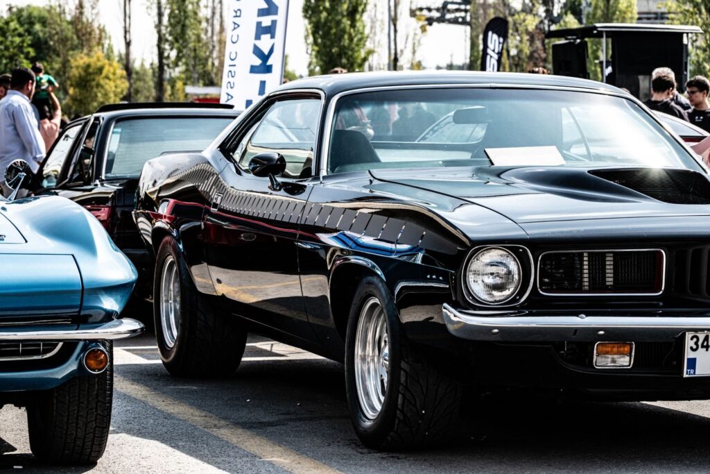 Vintage muscle cars on display at an auto show in Ankara, showcasing sleek design and classic style.