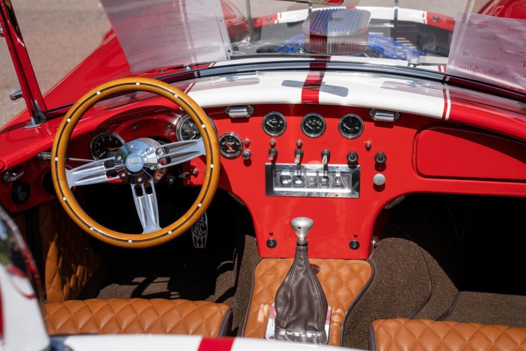 Detailed view of a classic Cobra car interior showcasing red design and dashboard.