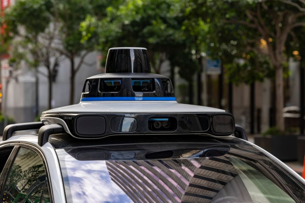 Detailed view of sensors atop an autonomous car, showcasing advanced technology in an urban setting.