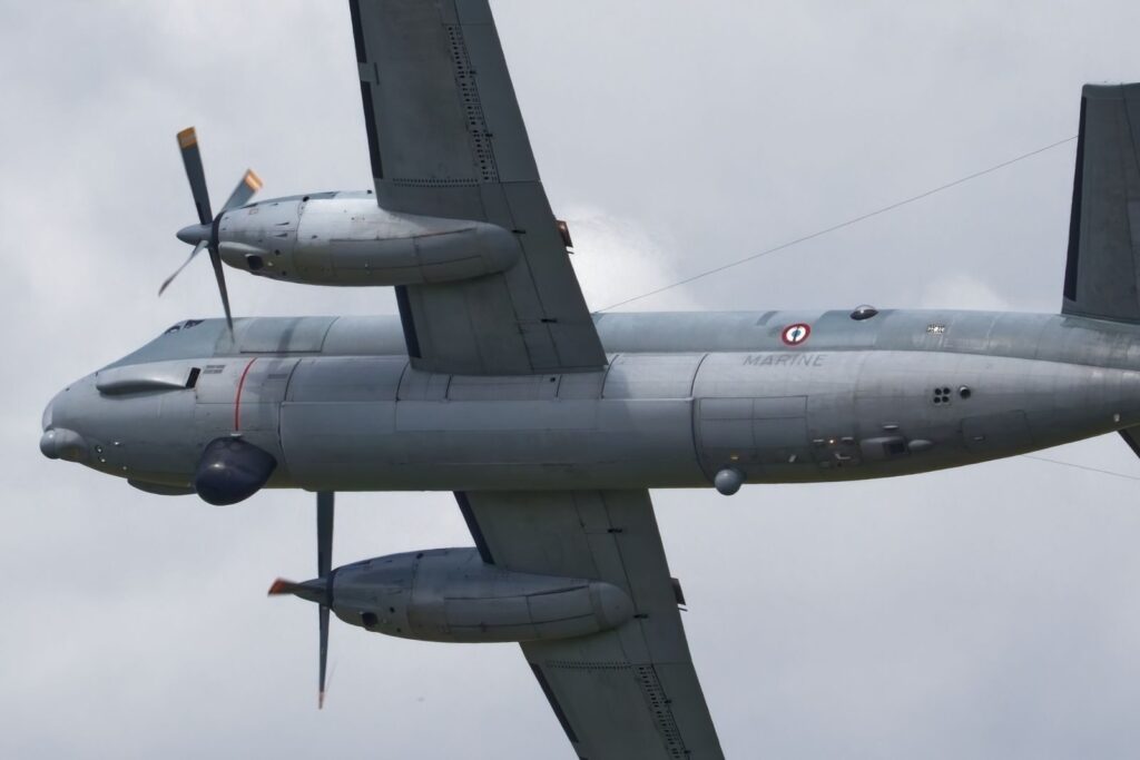 Close-up view of a military aircraft in flight against a cloudy background.