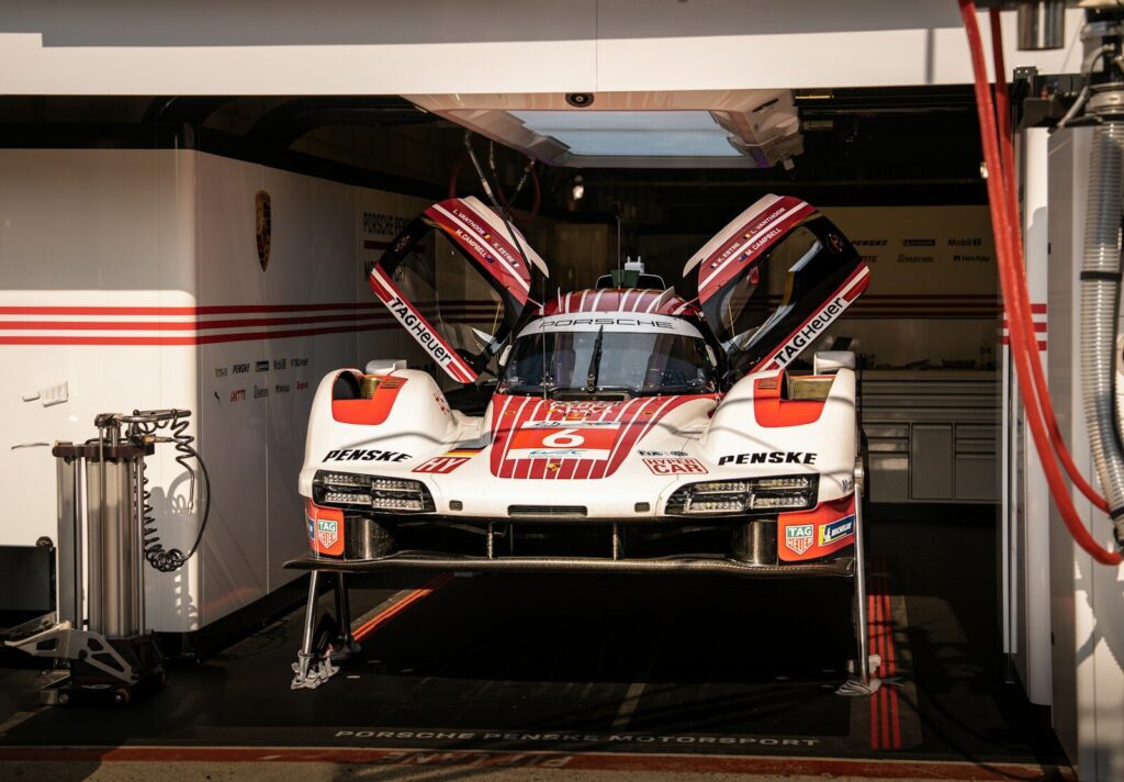Race car with open doors in a garage