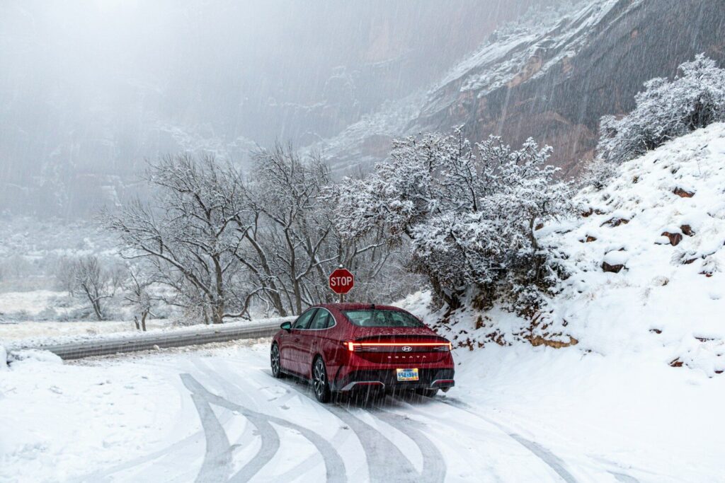 Red car driving on a snowy road