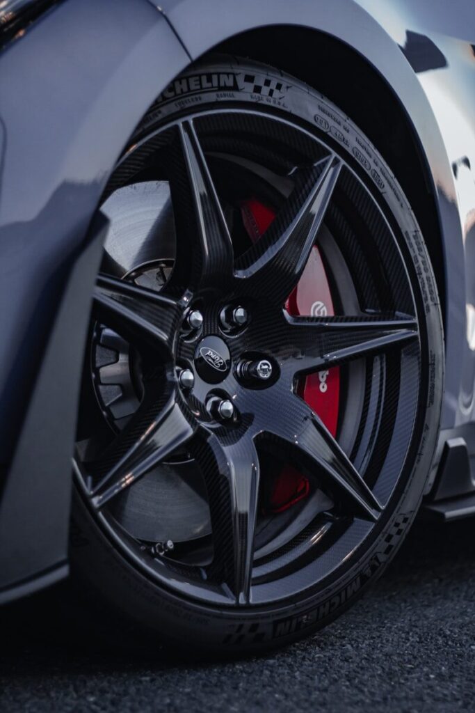 Close-up of a black car wheel with red brake calipers