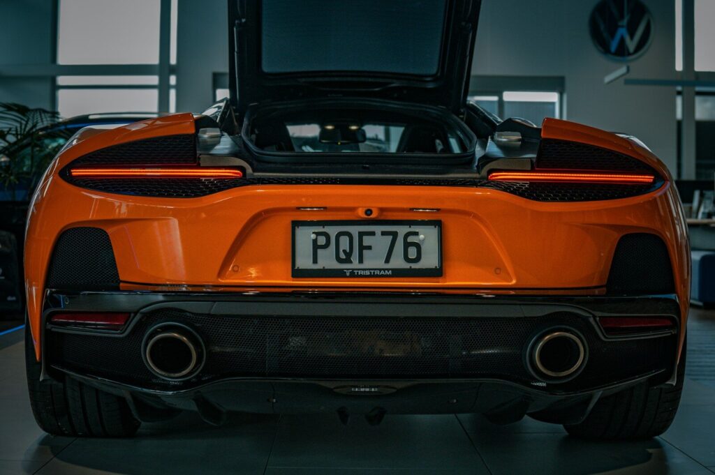 the rear end of an orange sports car