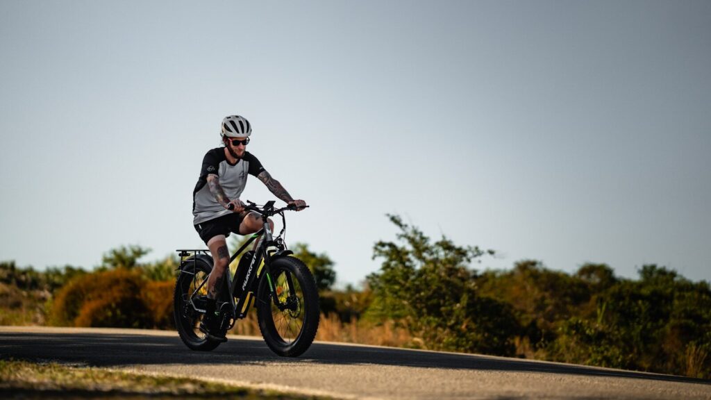 a man riding a bike down a rural road