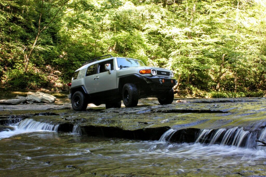 white crew cab pickup truck on river