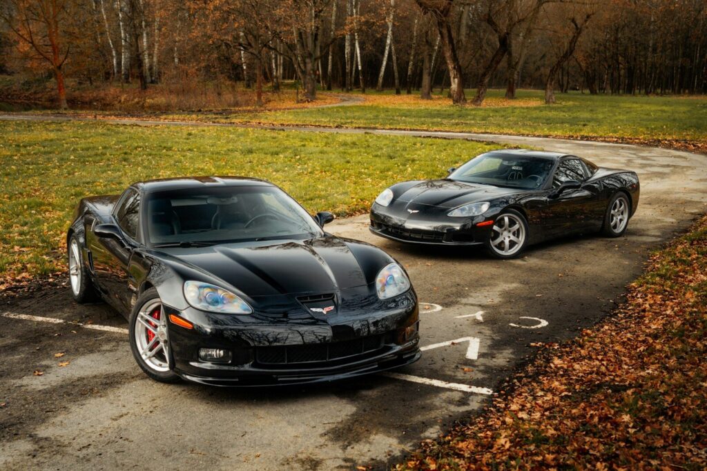 Two black sports cars parked in a parking lot