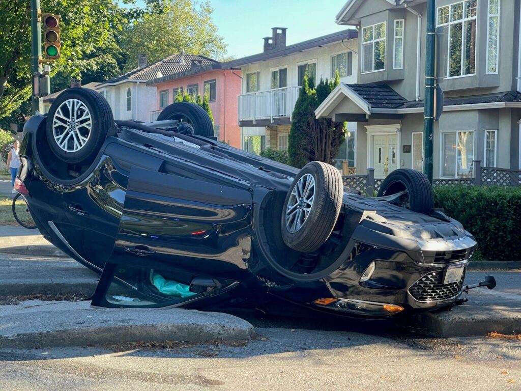 A car overturned on its side on a street