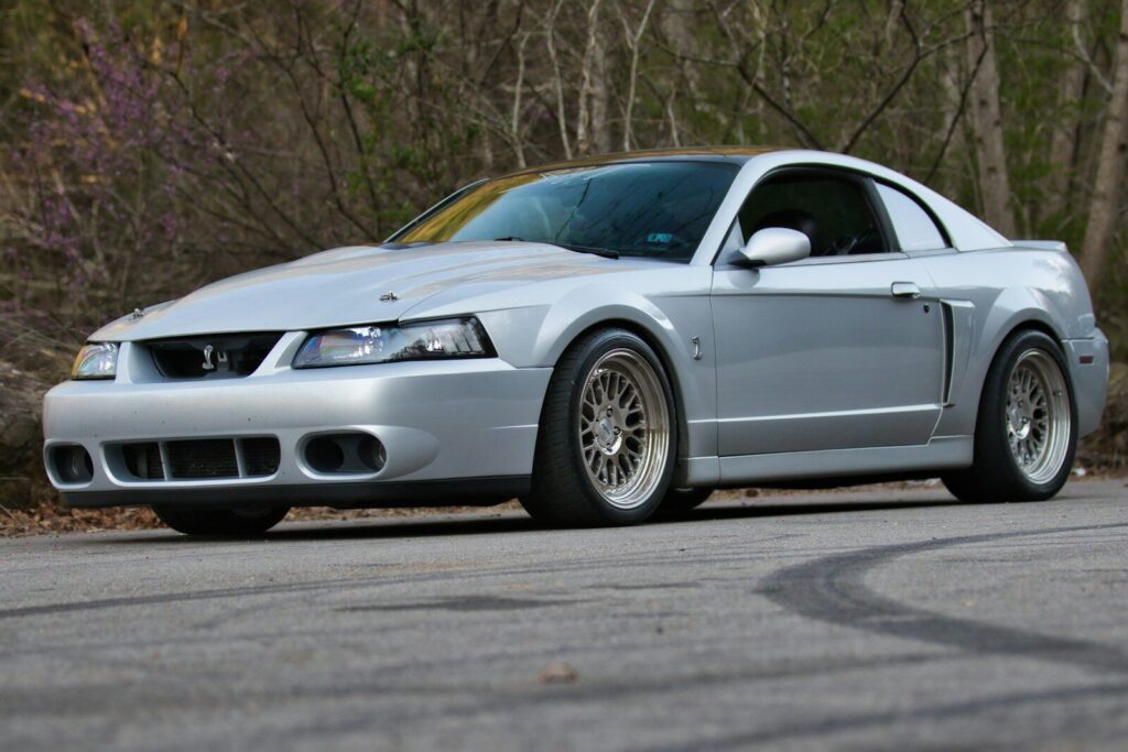 Silver ford mustang parked on a paved road