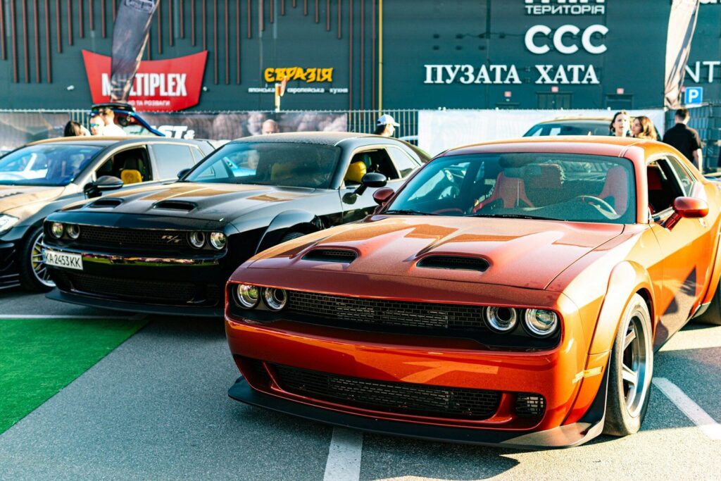 Several powerful muscle cars parked at an outdoor event.