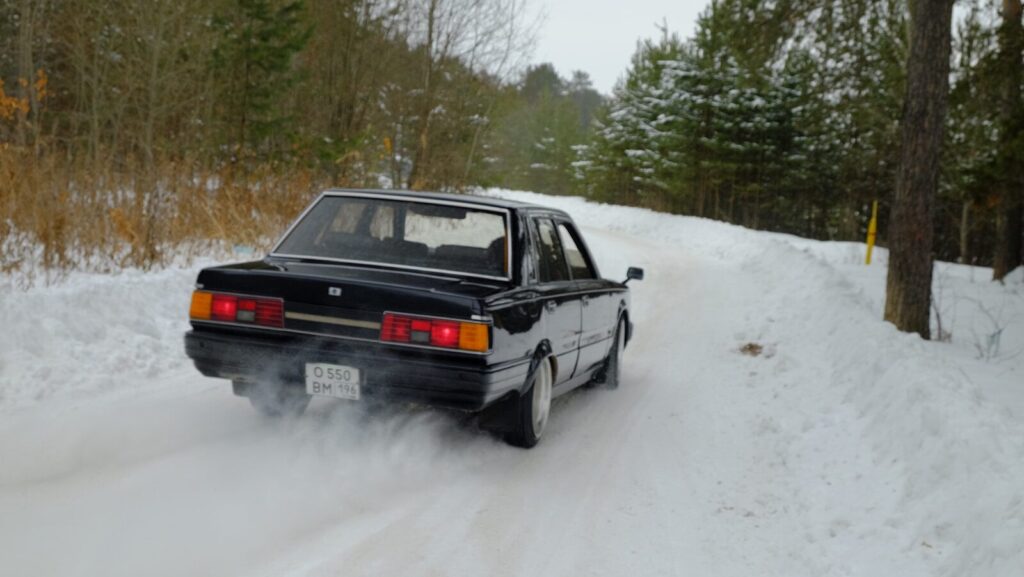black sedan on snow covered ground during daytime