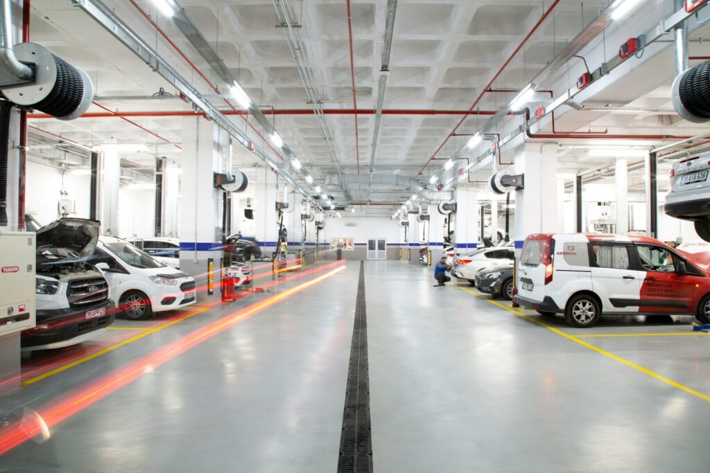 A large warehouse with many cars parked in it