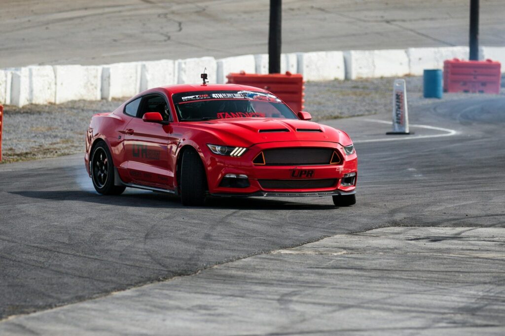 A red car drifts around a race track.