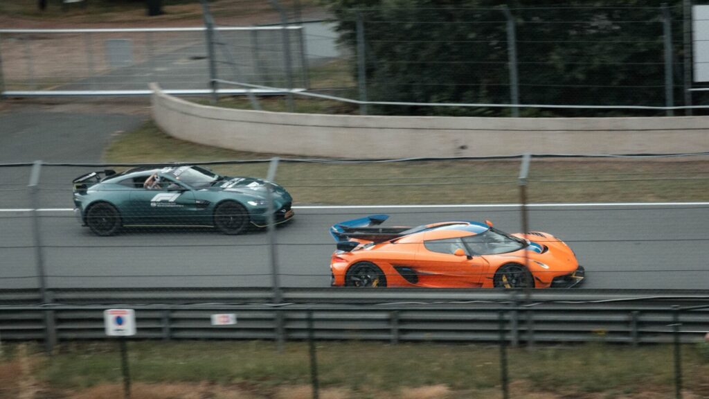 Orange and green sports cars speeding on a race track