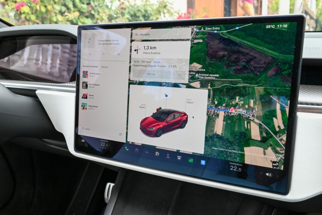 Interior view of a vehicle with a high-tech navigation touchscreen showing a route.