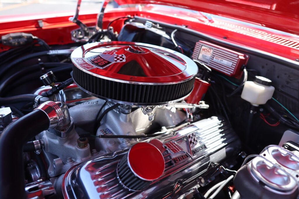 Detailed view of a powerful classic car engine under the hood showcasing intricate parts.