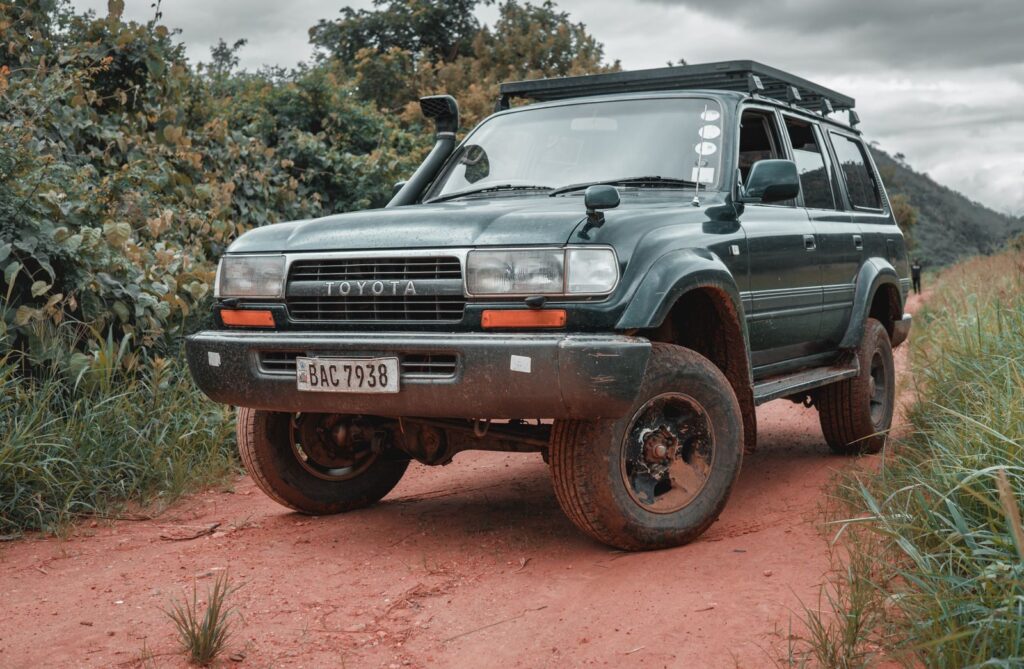 Toyota Land Cruiser navigating a rural dirt road in Kafue, Lusaka Province, under cloudy skies.
