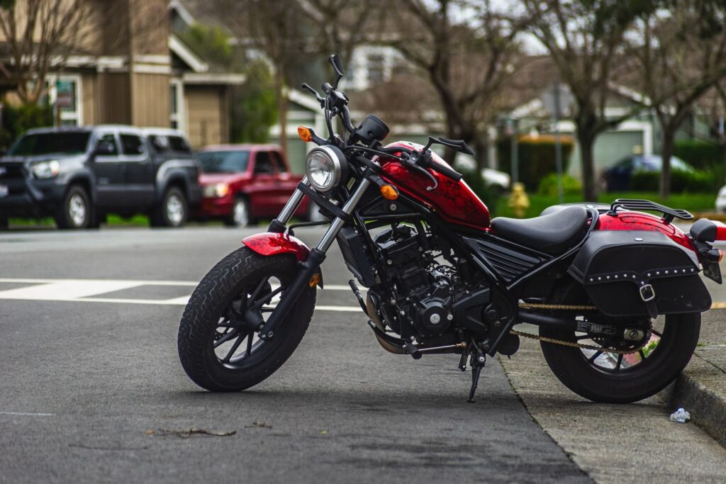 A striking red motorcycle parked on an urban street corner showcasing urban lifestyle.