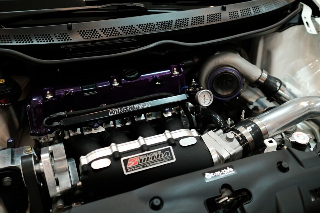 Detailed view of a customized car engine featuring a turbocharger and performance parts.