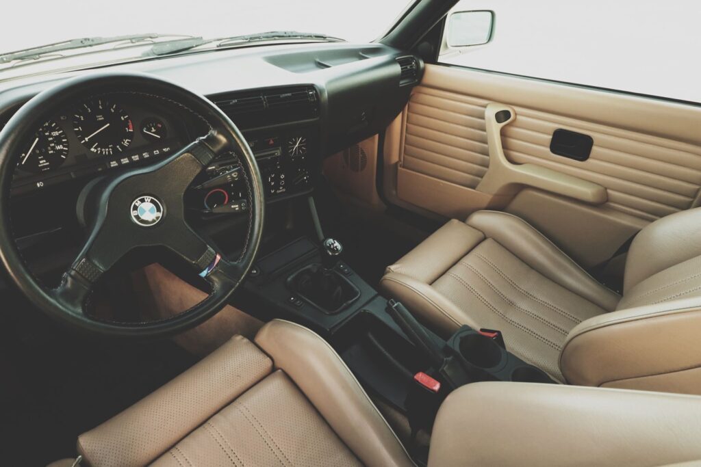 Explore the elegant interior of a classic BMW, showcasing leather seats and a detailed dashboard.