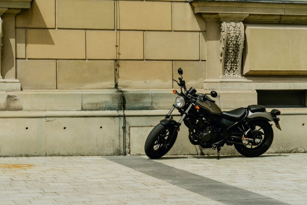 A classic motorcycle parked beside an ornate urban building wall in Munich, Germany.