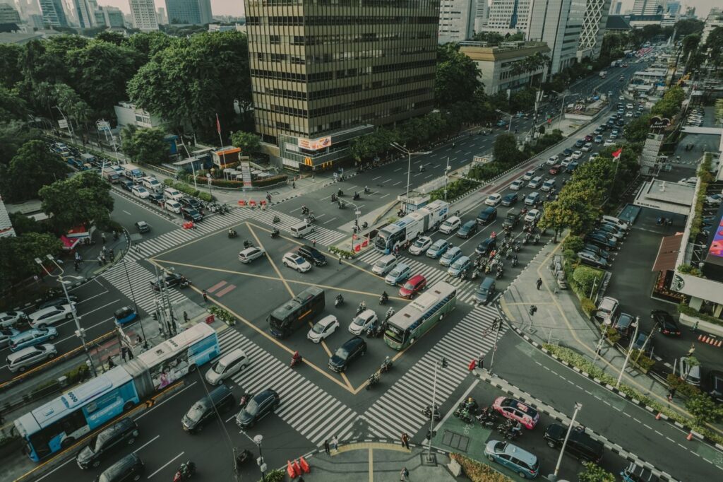 A bustling aerial view of a busy traffic intersection in Jakarta, Indonesia filled with vehicles and pedestrians.