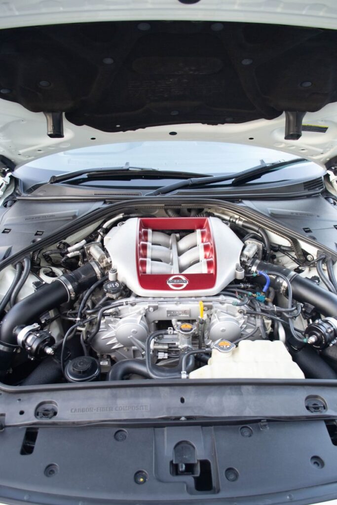 Close-up view of a high-performance car engine with a red intake manifold, showcasing mechanical design.
