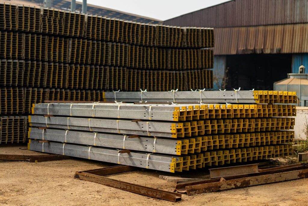 Stacked metal beams in an industrial yard, ideal for construction and architecture themes.