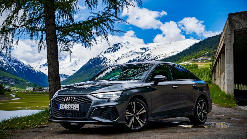 a grey car parked in front of a mountain