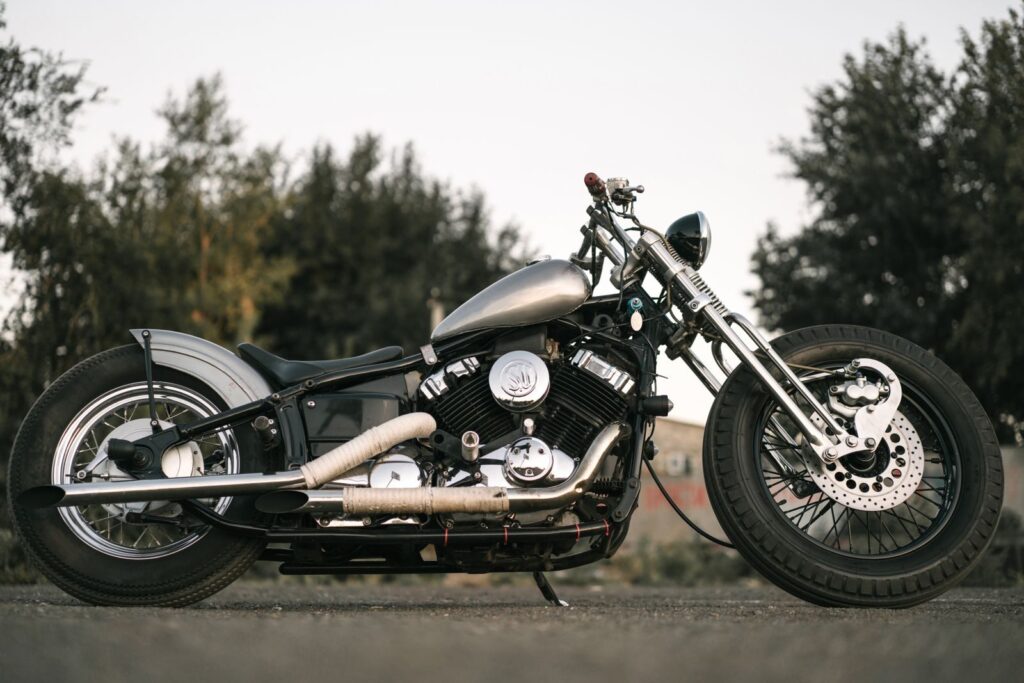 Side view of a classic vintage motorcycle parked outdoors on the road.