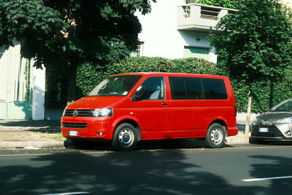 A red van parked on the side of the road