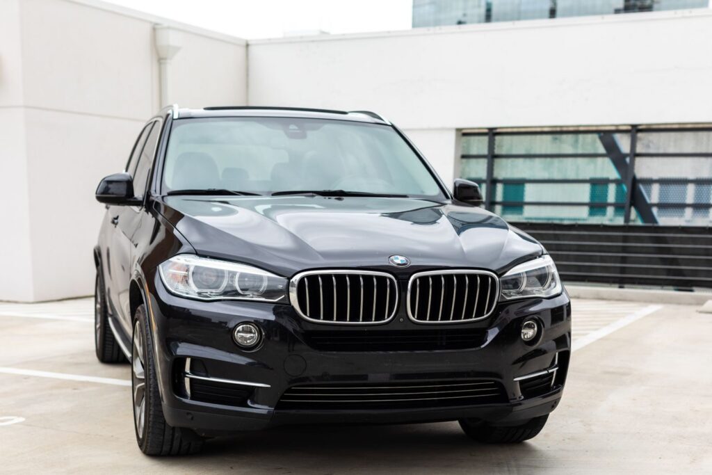 Modern black BMW X5 SUV parked in an urban city environment, showcasing luxury design.